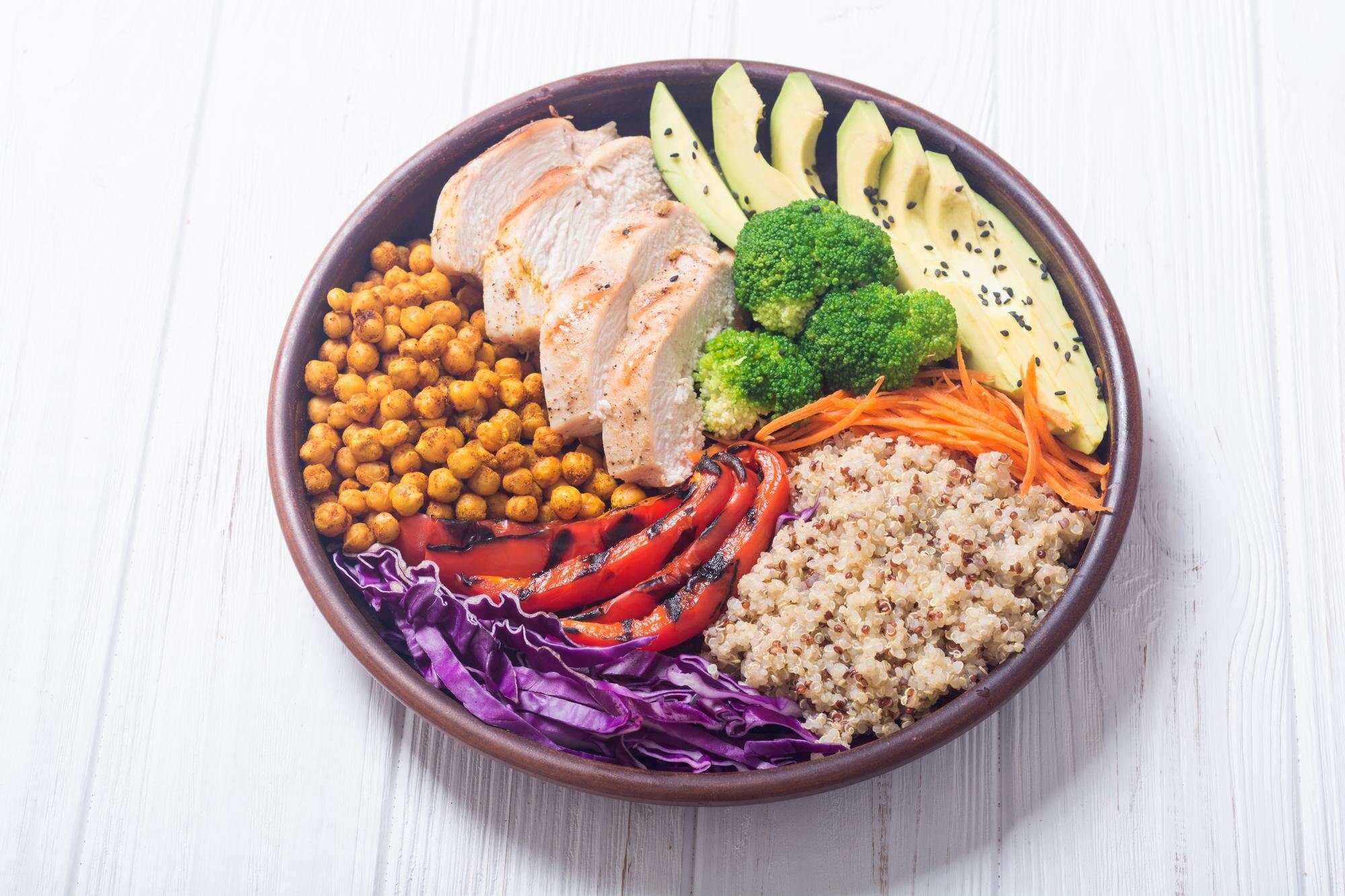 A nourishing bowl with avocado, chicken, quinoa, chickpeas and colourful vegetables — foods often included in a balanced, blood-sugar-supportive eating approach